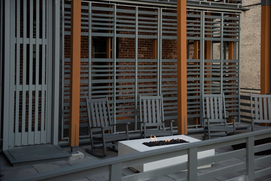 Rear patio with rocking chairs around a lit firepit