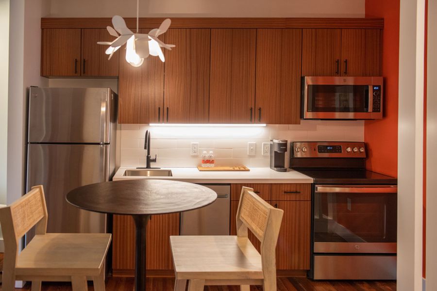 Eat-in kitchen with sapele wood cabinetry, stainless steel appliances and a round bistro table
