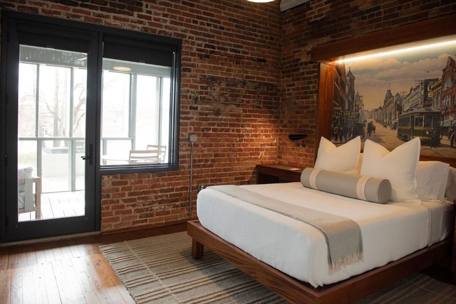Second bedroom with a backlit headboard postcard of a historic Danville street and trolley, beside a door to the rear porch