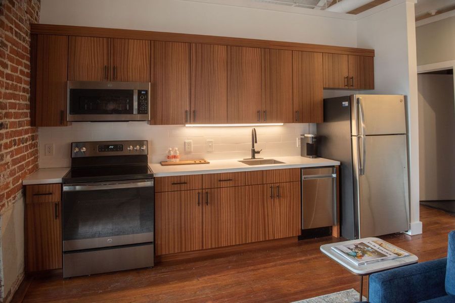 Full kitchen with sapele wood cabinetry, under-cabinet lighting and stainless steel appliances