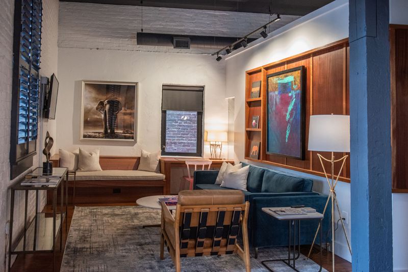 Living room with teal sofa, sapele wood gallery wall and original artwork